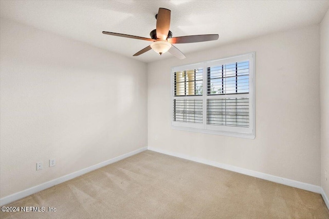 empty room with ceiling fan and light carpet