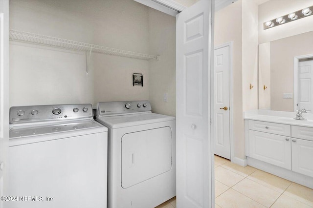 laundry room featuring washer and dryer, light tile patterned floors, and sink