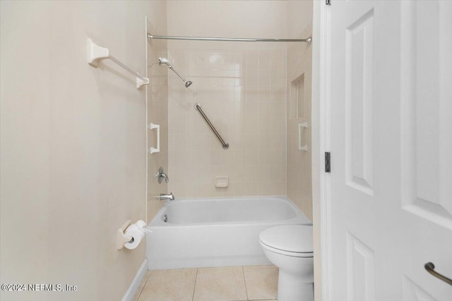 bathroom with tile patterned flooring, tiled shower / bath combo, and toilet