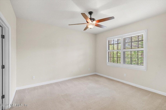 empty room featuring light carpet and ceiling fan