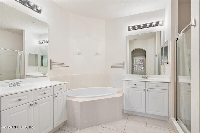 bathroom with vanity, a textured ceiling, separate shower and tub, and tile patterned floors