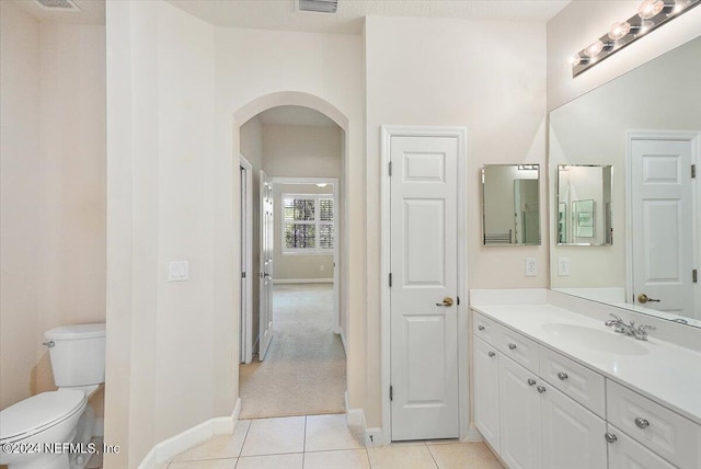 bathroom featuring tile patterned flooring, vanity, and toilet