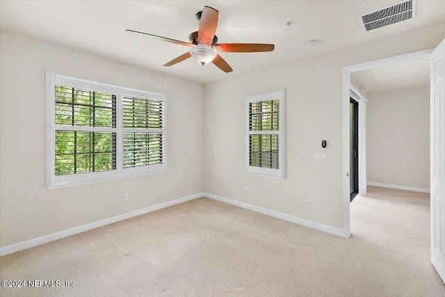 spare room featuring ceiling fan and light carpet