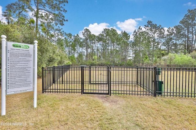 view of gate with a lawn