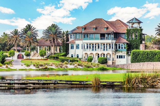 rear view of house featuring a balcony and a water view