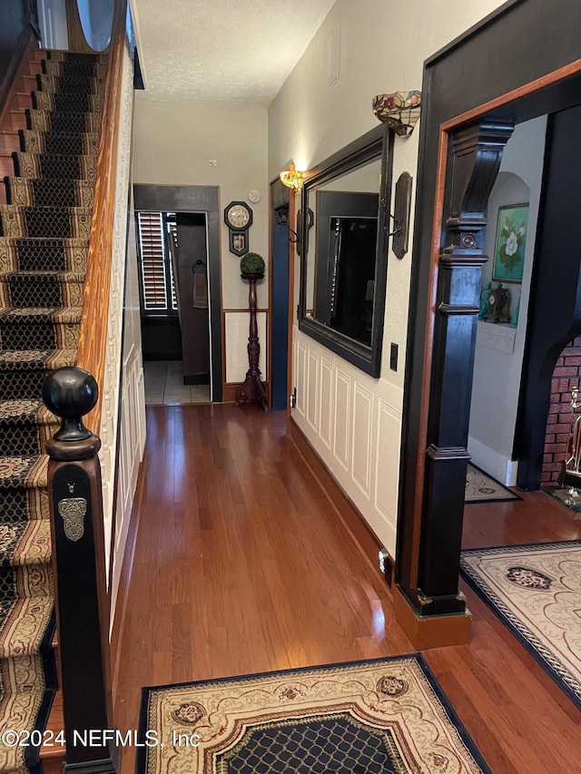 hallway featuring dark hardwood / wood-style floors and a textured ceiling