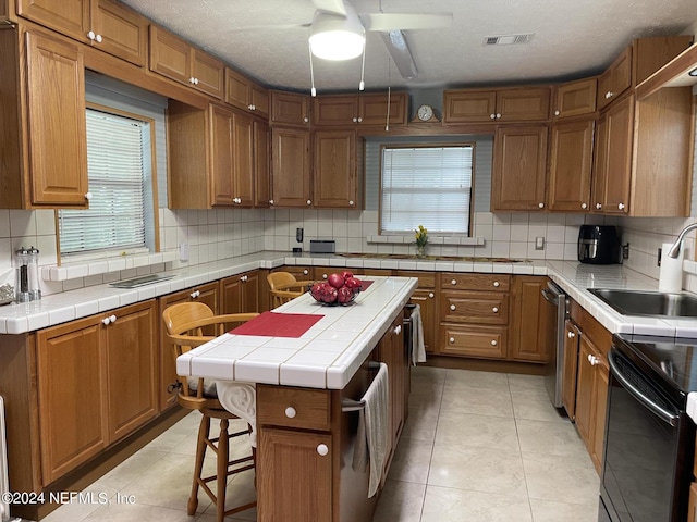 kitchen featuring tile countertops, sink, and a kitchen island