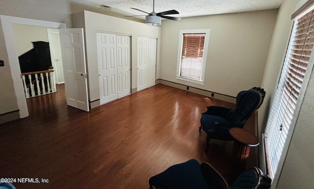 unfurnished room featuring ceiling fan, dark hardwood / wood-style floors, and a textured ceiling