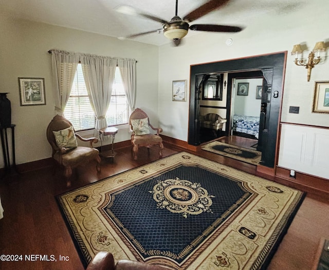 living room with dark wood-type flooring and ceiling fan