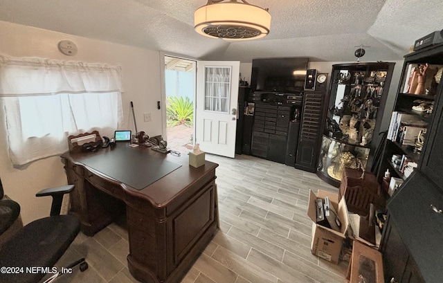 office area with lofted ceiling and a textured ceiling