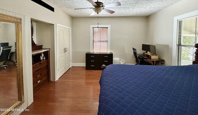 bedroom with ceiling fan, dark hardwood / wood-style floors, and a textured ceiling