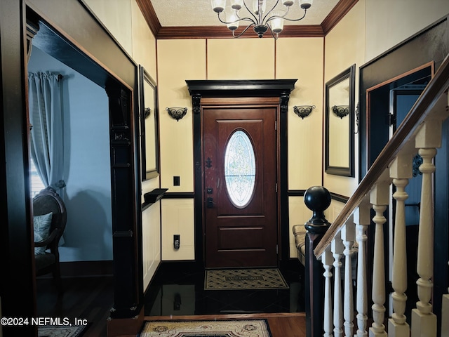 entrance foyer featuring hardwood / wood-style flooring, ornamental molding, and an inviting chandelier