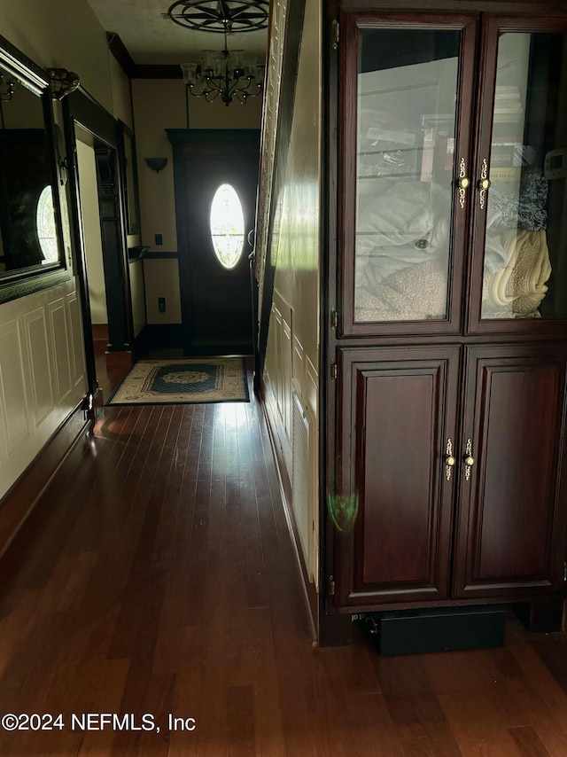 doorway to outside featuring dark hardwood / wood-style floors and a chandelier