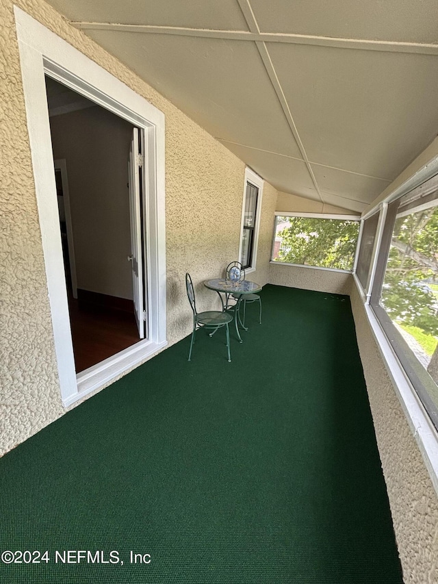 unfurnished sunroom featuring vaulted ceiling