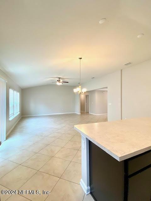 kitchen featuring light tile patterned flooring, hanging light fixtures, and ceiling fan with notable chandelier