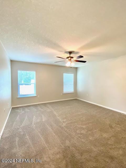 empty room featuring carpet, a textured ceiling, and ceiling fan