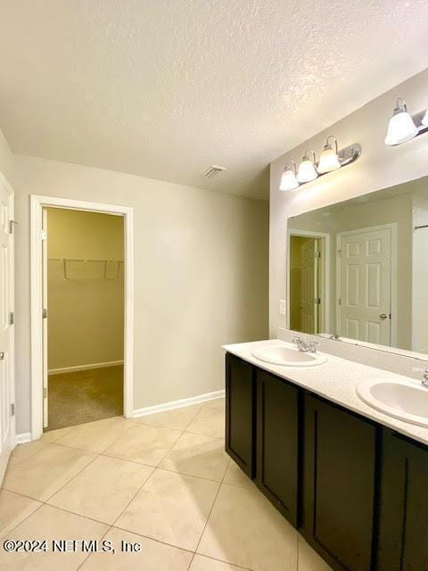 bathroom featuring tile patterned flooring, a textured ceiling, and vanity