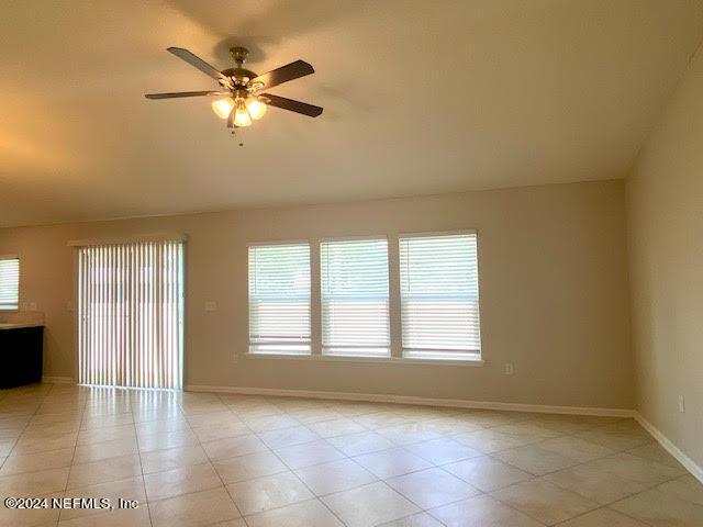 empty room featuring ceiling fan and a healthy amount of sunlight