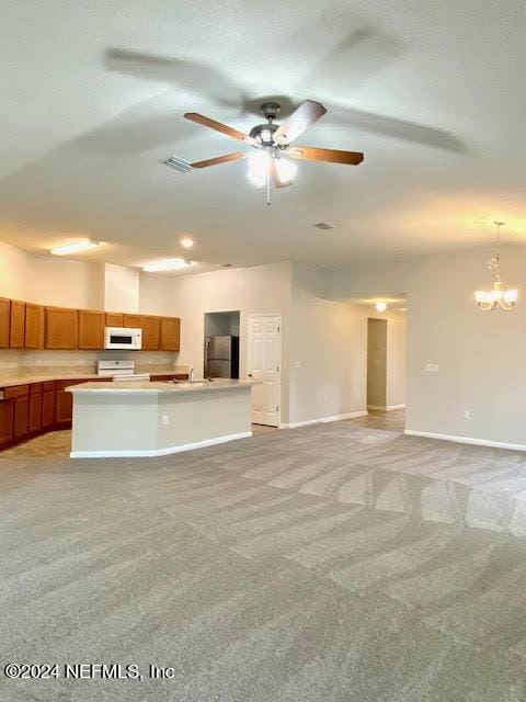 unfurnished living room with ceiling fan with notable chandelier and light colored carpet