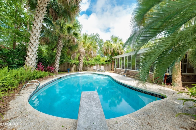 view of pool with a diving board