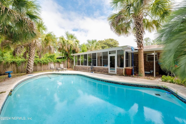 view of swimming pool with a sunroom