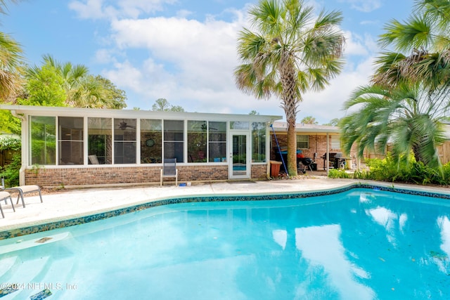 view of swimming pool with a sunroom