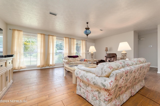 living room featuring a textured ceiling and light hardwood / wood-style floors