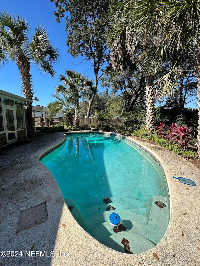 view of pool featuring a sunroom and a patio