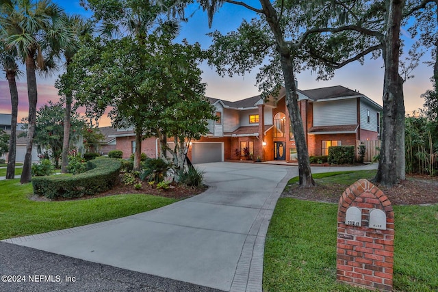 view of front of property with a garage, driveway, and a front lawn