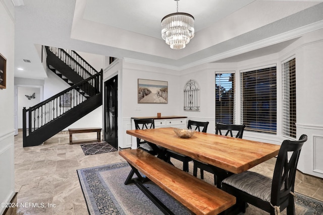 dining room with an inviting chandelier, visible vents, stairway, and a tray ceiling