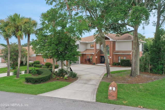 view of front of property with driveway, brick siding, and a front lawn