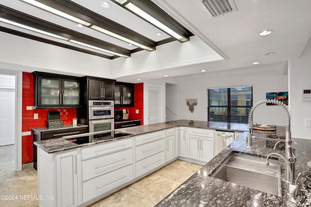 kitchen with double oven, black electric cooktop, a sink, visible vents, and glass insert cabinets