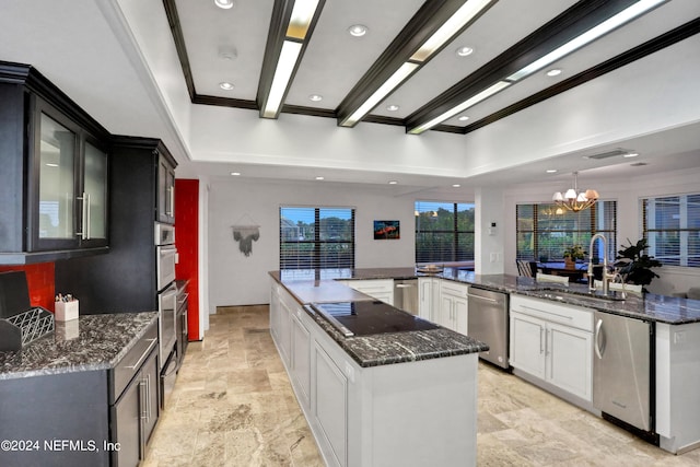 kitchen featuring appliances with stainless steel finishes, a notable chandelier, a sink, and a large island