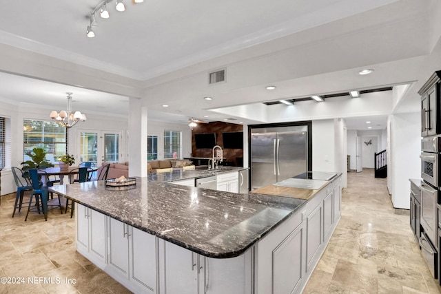 kitchen with visible vents, a spacious island, ornamental molding, stainless steel appliances, and a sink