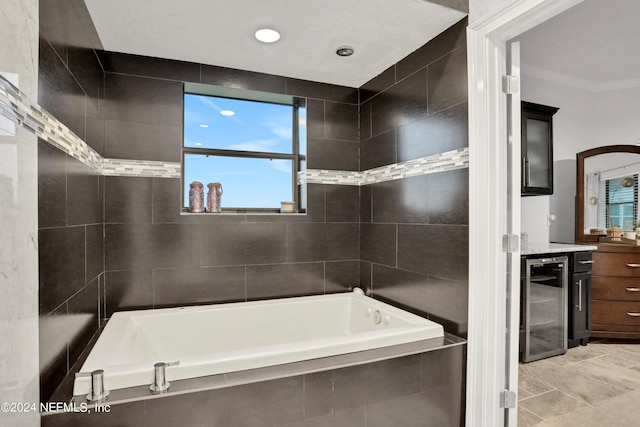 bathroom featuring beverage cooler, a garden tub, vanity, and tile walls