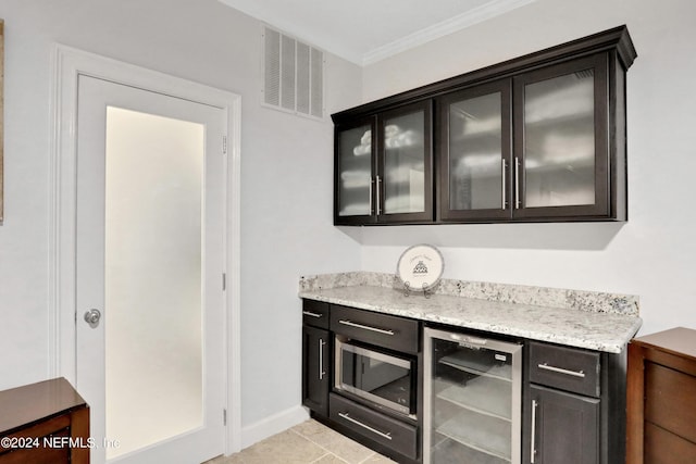 bar with light tile patterned flooring, beverage cooler, visible vents, stainless steel microwave, and crown molding