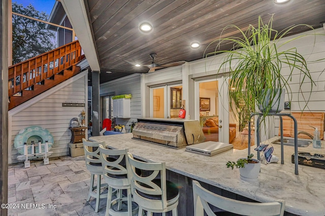 view of patio featuring stairs, ceiling fan, exterior kitchen, and outdoor wet bar