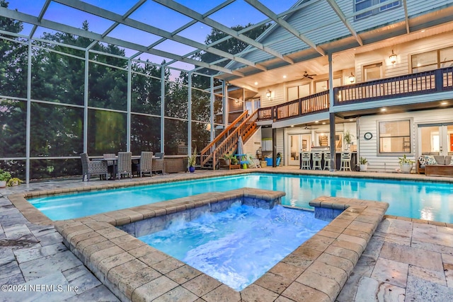 outdoor pool featuring ceiling fan, a patio, a lanai, and stairs