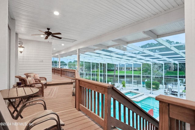 sunroom / solarium with a water view and a ceiling fan