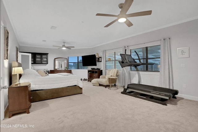 carpeted bedroom with a ceiling fan, visible vents, crown molding, and baseboards