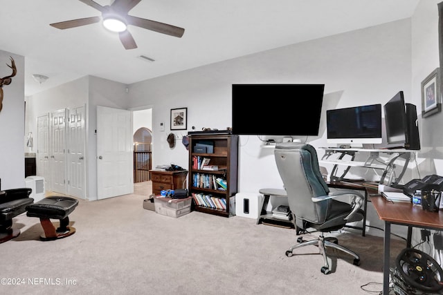 carpeted office with visible vents and a ceiling fan