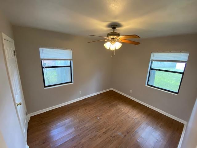 empty room featuring dark hardwood / wood-style floors, plenty of natural light, and ceiling fan