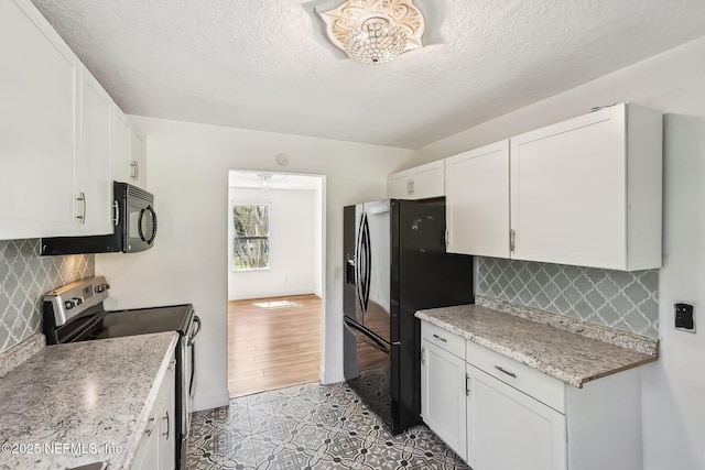 kitchen with backsplash, white cabinets, a textured ceiling, and black appliances