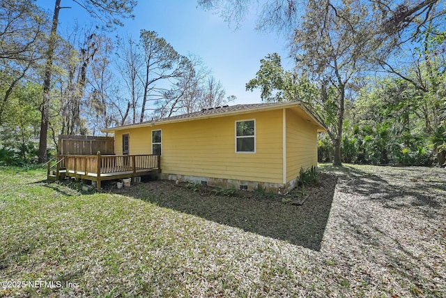 back of house with a lawn, a wooden deck, and fence