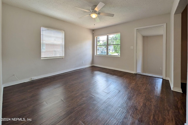 spare room featuring a textured ceiling, ceiling fan, and dark wood-type flooring