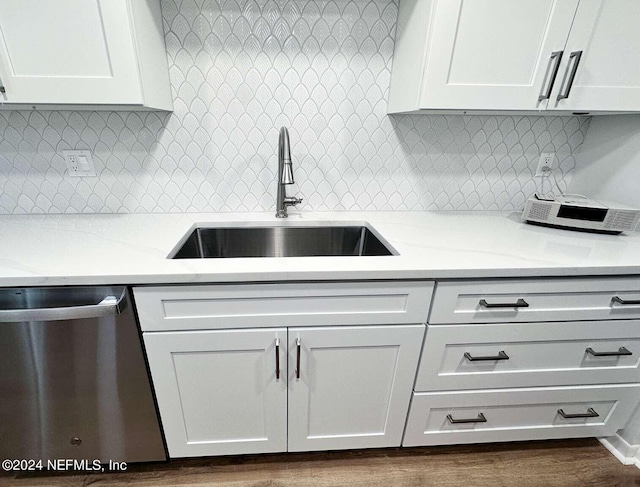 kitchen with sink, dishwasher, tasteful backsplash, light stone countertops, and white cabinets