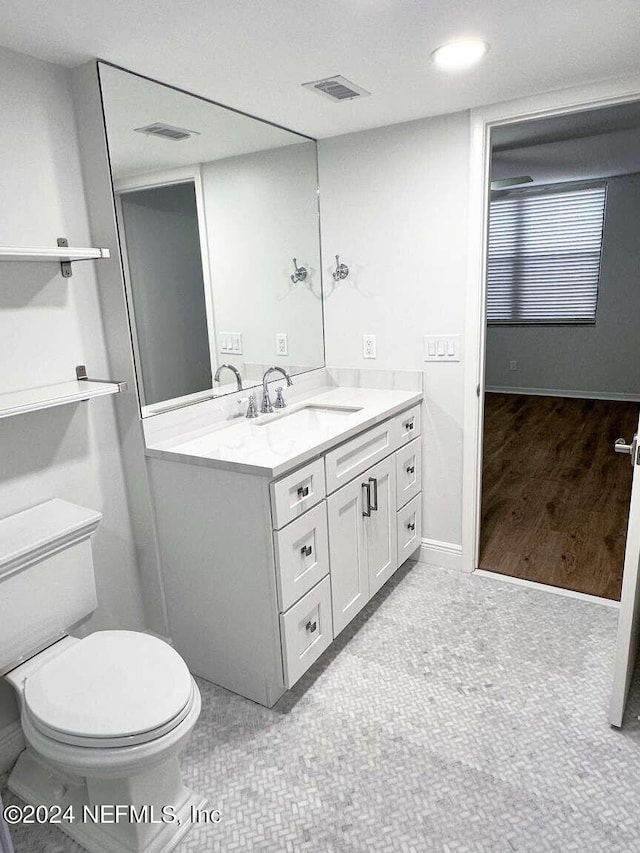 bathroom featuring vanity, tile patterned flooring, and toilet