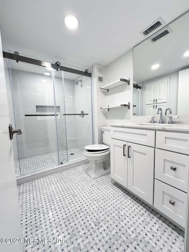 bathroom with vanity, toilet, and a shower with door