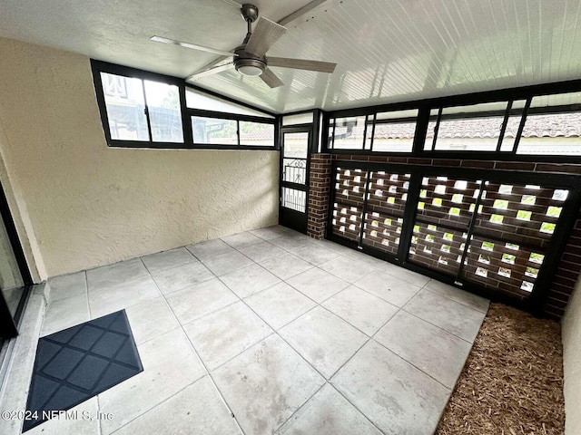 unfurnished sunroom featuring ceiling fan