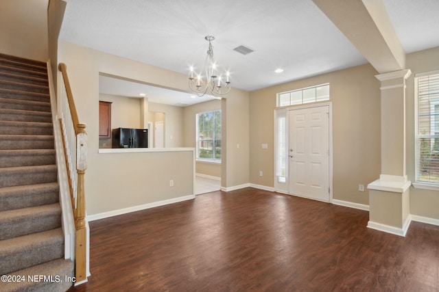 entrance foyer with dark hardwood / wood-style floors and a notable chandelier